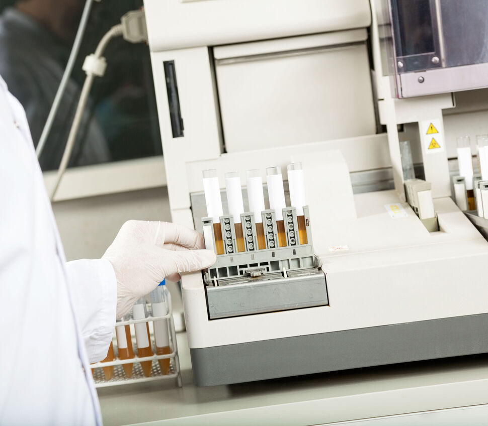 Technician Using Urine Analyzer In Lab