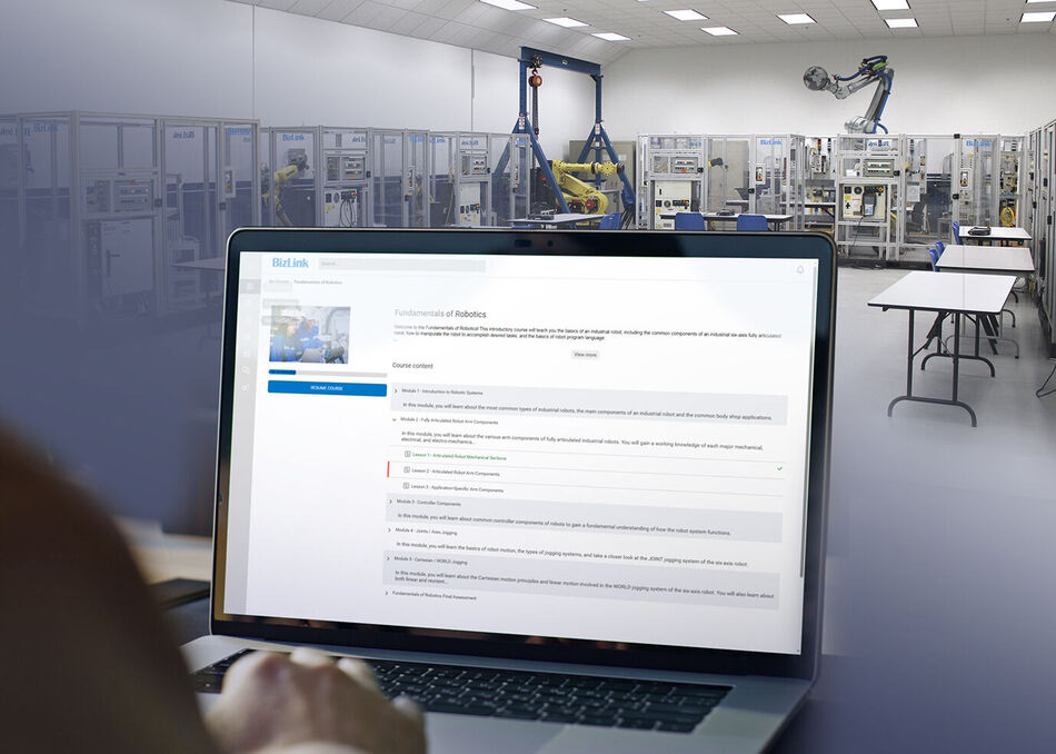 Training lab with robotic demos and a monitor showing BizLink Online Training