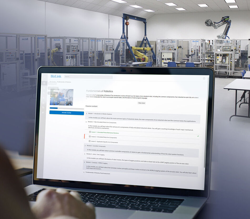 Training lab with robotic demos and a monitor showing BizLink Online Training